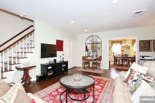 living room featuring dark wood-type flooring and an inviting chandelier