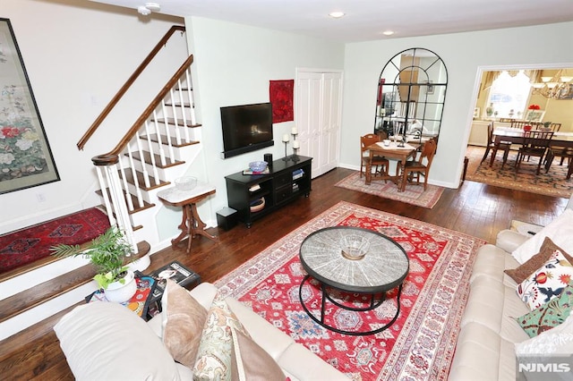 living room featuring dark wood-type flooring and a chandelier