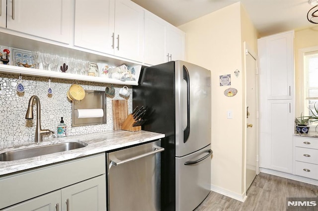 kitchen featuring tasteful backsplash, appliances with stainless steel finishes, sink, and white cabinets