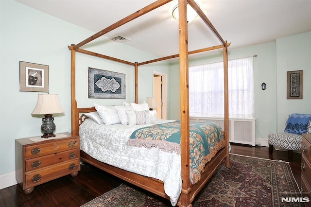 bedroom featuring dark hardwood / wood-style flooring and radiator