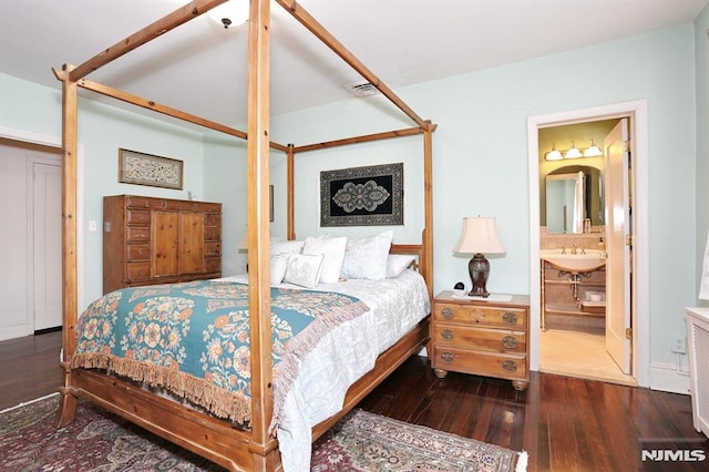 bedroom with ensuite bathroom, dark wood-type flooring, and a closet