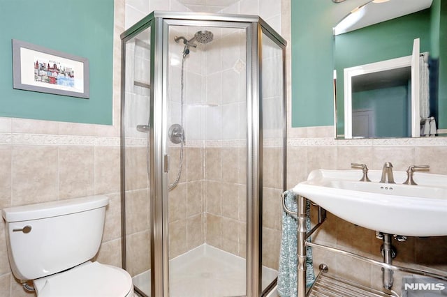 bathroom featuring sink, tile walls, an enclosed shower, and toilet