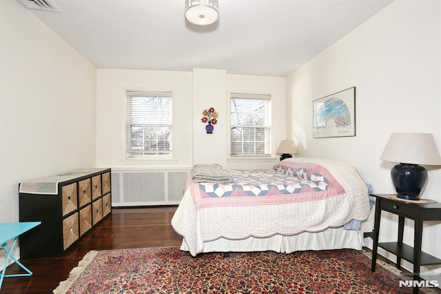 bedroom featuring radiator heating unit and dark hardwood / wood-style floors