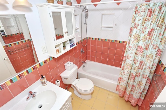 full bathroom with shower / bathtub combination with curtain, tile walls, vanity, tile patterned floors, and toilet