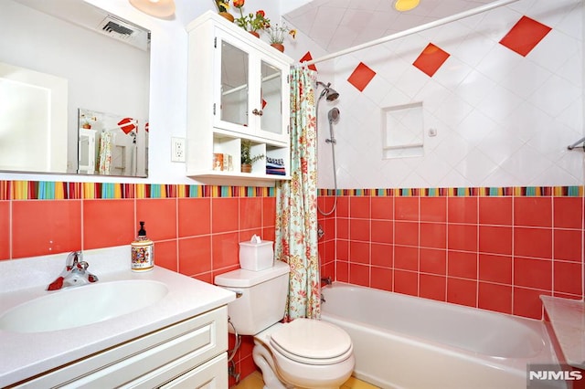 full bathroom with tasteful backsplash, tile walls, vanity, shower / tub combo, and toilet