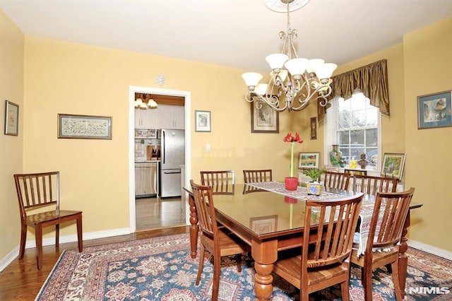 dining room with dark wood-type flooring and a chandelier