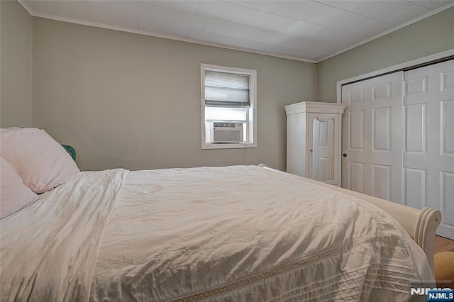 bedroom featuring cooling unit, hardwood / wood-style flooring, ornamental molding, and a closet