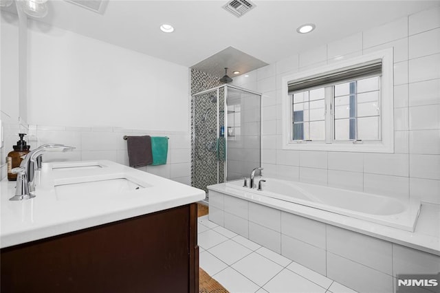 bathroom featuring vanity, shower with separate bathtub, tile walls, and tile patterned floors