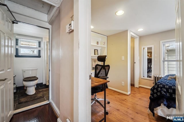 bedroom featuring connected bathroom and hardwood / wood-style flooring