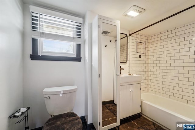 full bathroom with tiled shower / bath combo, vanity, and toilet