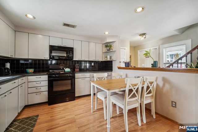 kitchen with white cabinetry, tasteful backsplash, light hardwood / wood-style flooring, and black appliances