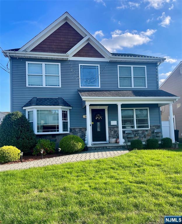 view of front of house with a porch and a front yard