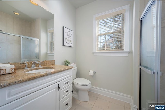 bathroom featuring toilet, vanity, baseboards, tile patterned floors, and a stall shower