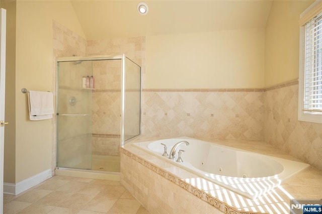 full bathroom with vaulted ceiling, a jetted tub, a shower stall, and tile patterned floors