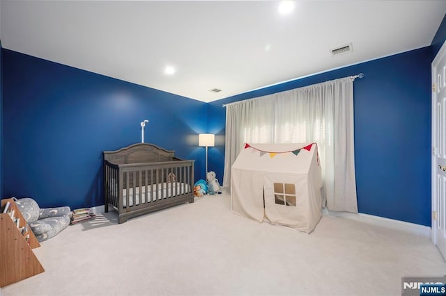 carpeted bedroom with a nursery area, recessed lighting, visible vents, and baseboards