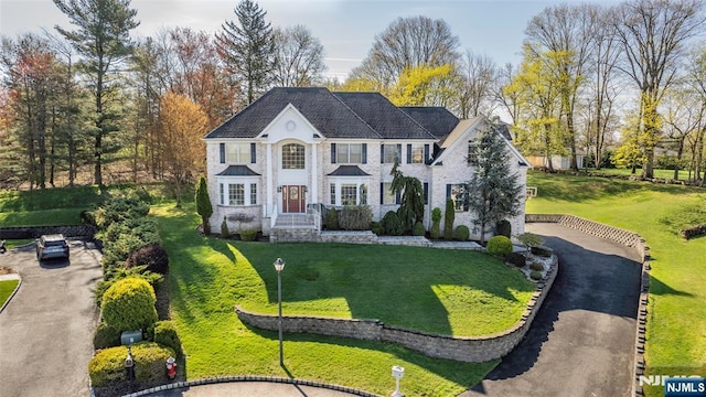 view of front of home featuring a front lawn and aphalt driveway