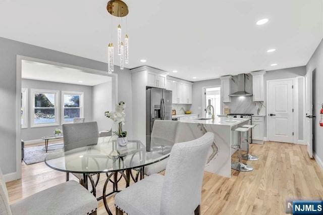 dining area featuring sink, a wealth of natural light, and light wood-type flooring