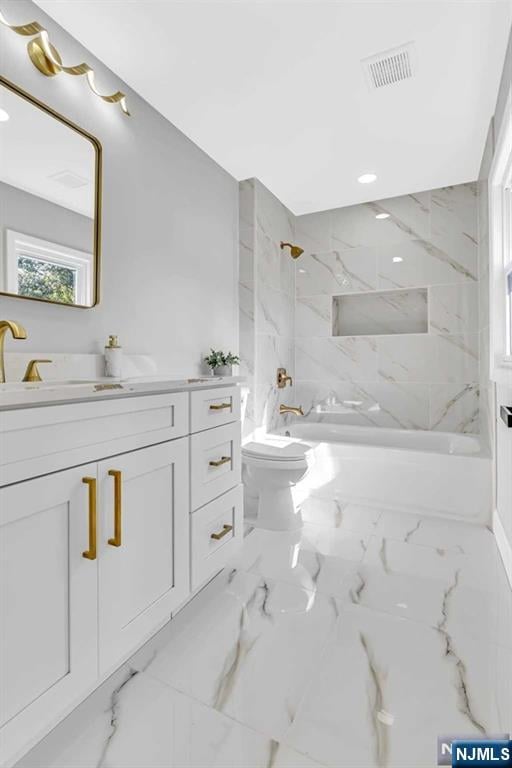 bathroom featuring vanity, toilet, and a tile shower