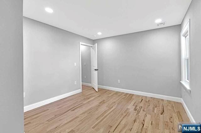 spare room featuring a wealth of natural light and light hardwood / wood-style flooring