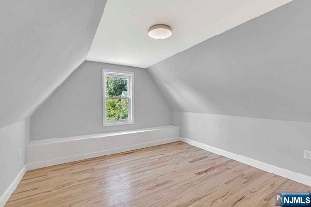 bonus room with vaulted ceiling and light hardwood / wood-style floors