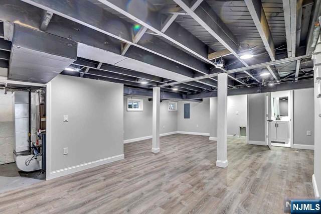 basement with hardwood / wood-style flooring and electric panel