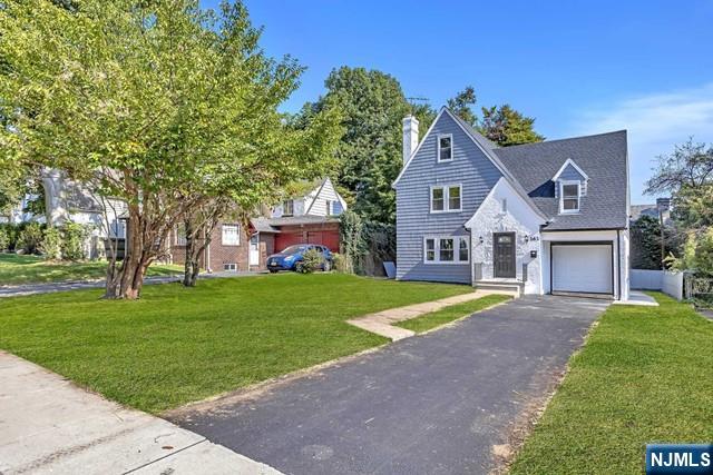 view of front of home with a garage and a front lawn