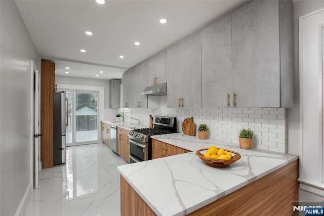 kitchen with light stone counters, backsplash, kitchen peninsula, and appliances with stainless steel finishes