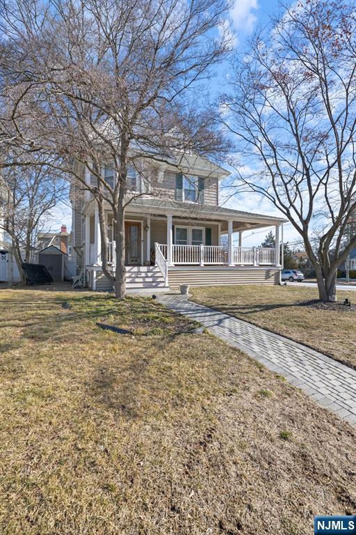 view of front of property featuring a storage shed, an attached carport, an outbuilding, a porch, and a front yard