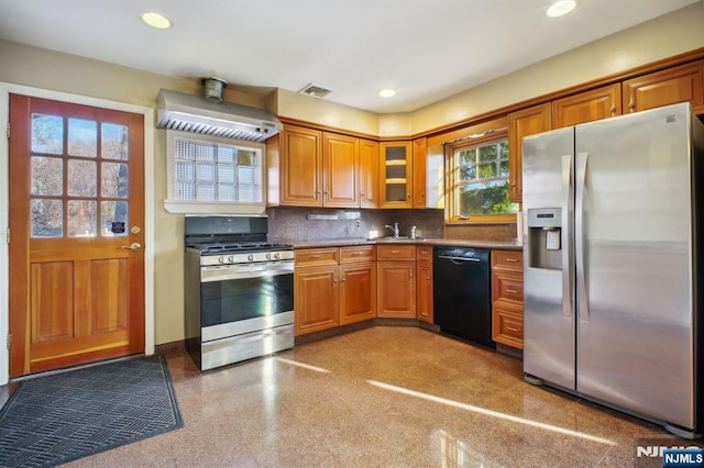 kitchen featuring appliances with stainless steel finishes, sink, wall chimney exhaust hood, and decorative backsplash