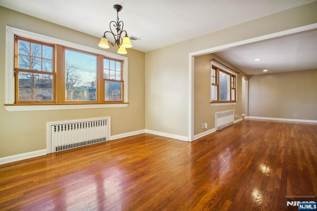 spare room with radiator heating unit and a healthy amount of sunlight