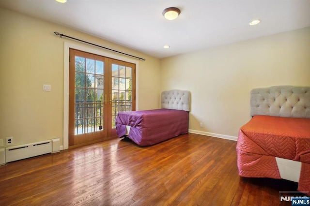 bedroom featuring a baseboard radiator, hardwood / wood-style floors, and access to exterior