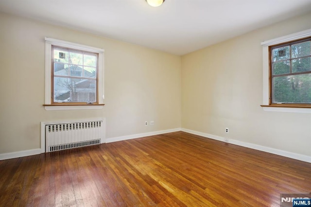 unfurnished room featuring wood-type flooring and radiator