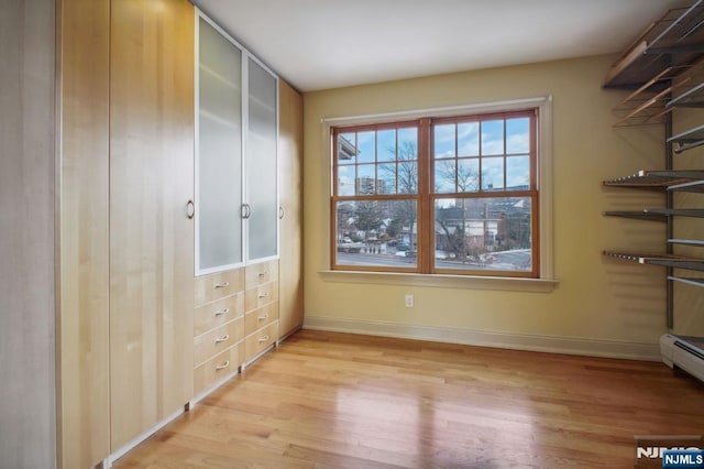 interior space with light hardwood / wood-style floors and a baseboard heating unit