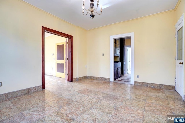 spare room featuring crown molding and a notable chandelier