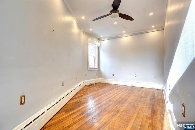 empty room with crown molding, light hardwood / wood-style floors, ceiling fan, and baseboard heating