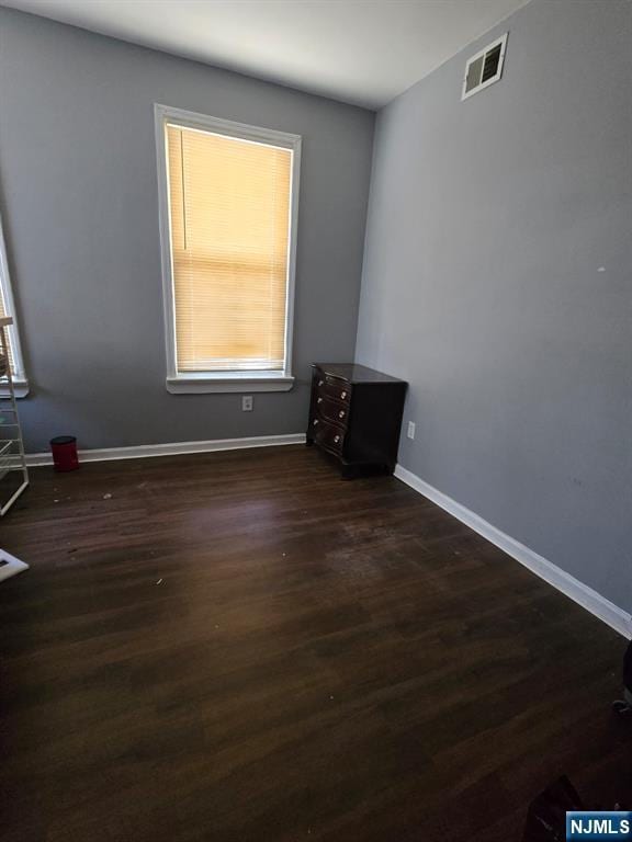 empty room with dark hardwood / wood-style flooring