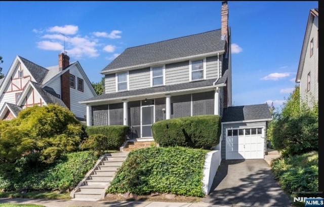 view of front facade featuring a garage and a sunroom