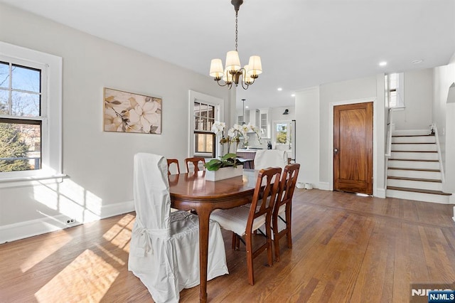 dining room with wood-type flooring and a chandelier