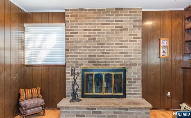 details featuring a brick fireplace, wooden walls, and ornamental molding