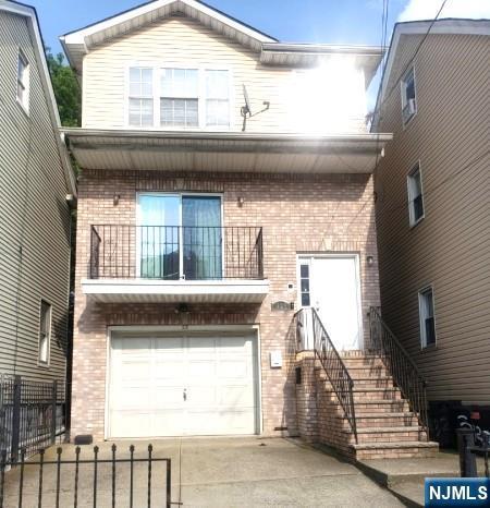 view of front of property with a balcony and a garage