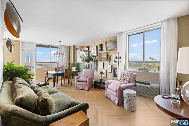 living room with light parquet floors, an inviting chandelier, a wealth of natural light, and a wall unit AC