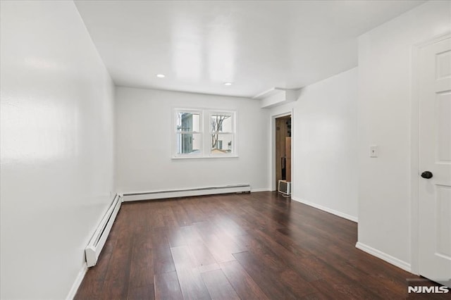 empty room with a baseboard radiator and dark hardwood / wood-style floors