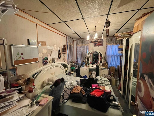 miscellaneous room with a paneled ceiling and wood walls