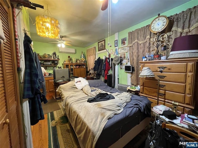 bedroom featuring an AC wall unit and ceiling fan