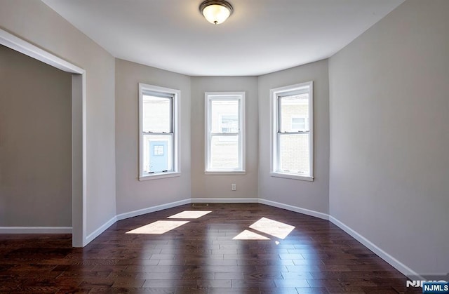 empty room with dark hardwood / wood-style floors