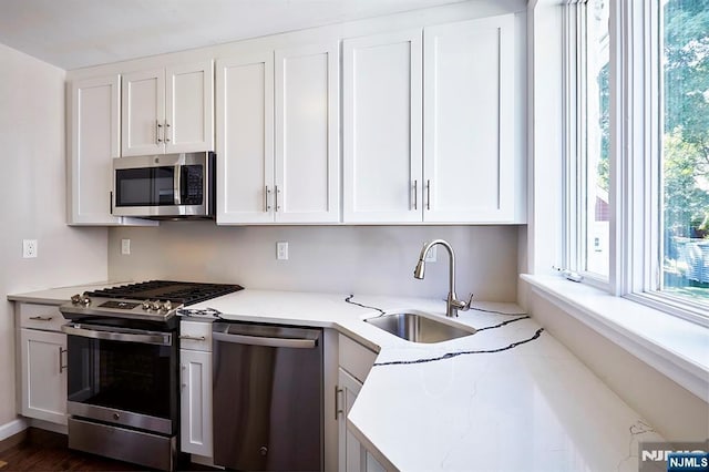 kitchen featuring white cabinetry, appliances with stainless steel finishes, and sink