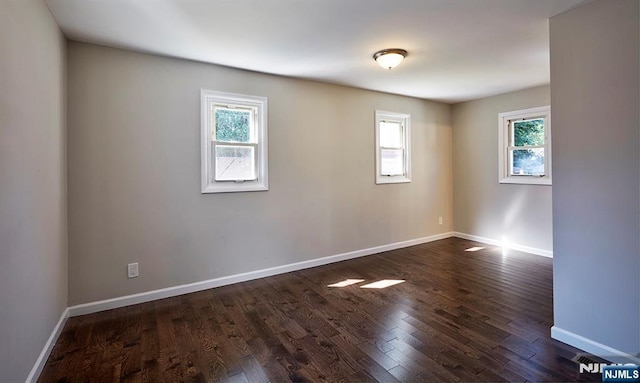 unfurnished room with dark wood-type flooring