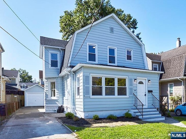 view of front of house featuring a garage, an outdoor structure, and a front yard