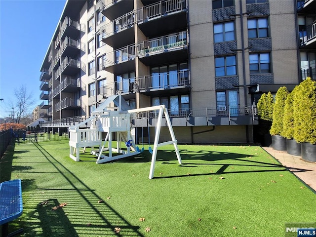 view of property's community with a playground and a yard