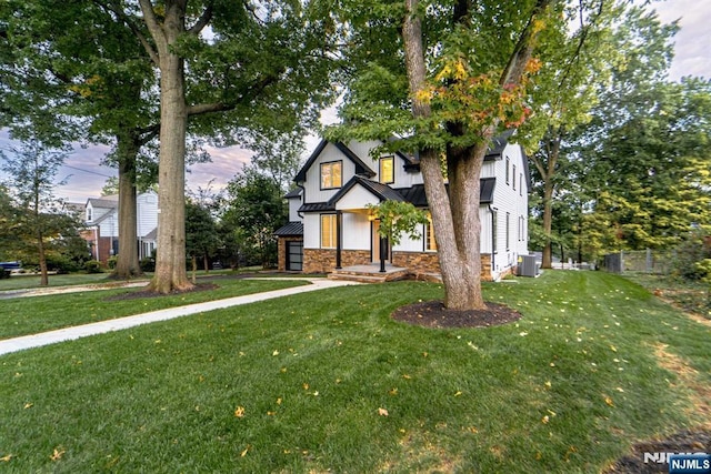 view of front of home featuring central AC unit and a front yard